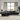 Modern black leather sectional sofa with reclining feature, set in a bright living room with large windows and contemporary decor.