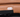 Close-up of a tan leather recliner control button, featuring two metal buttons for adjusting the seating position.