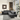 Modern black leather sectional sofa with reclining feature, set in a bright living room with large windows and contemporary decor.