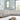 Light gray leather sectional sofa with reclining features, set in a modern living room with natural light and minimalist decor.