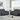 Gray leather reclining loveseat and sofa set in a modern living room with large windows, featuring clean lines and contemporary design.