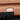 Close-up of a tan leather recliner control button, featuring two metal buttons for adjusting the seating position.