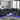 Black leather sectional sofa with reclining features, cup holders, and LED lighting, set in a modern living room with a sleek glass coffee table.