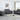 Gray leather sofa set with reclining features, including a loveseat and armchair, set in a bright and modern living room with large windows.