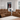 A cozy living room featuring a brown leather reclining sofa set including a reclining loveseat with cupholders, and a comfortable sofa. The furniture is arranged around a light-colored rug, with large windows providing natural light.